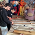 Costruzione della base delle maschere giganti (stecche di tapparelle, legno, cerniere) con i ragazzi del Carnevale Sociale di Pianura. Condivisioni del GRIDAS, febbraio 2025. Ph Maria Reitano.